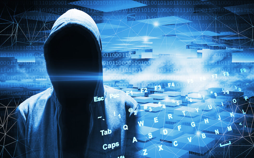 Hacker in a hood on dark blue digital background